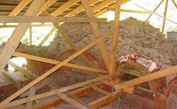 Das Gerüst im Hauptsaal; unter dem Schutzdach werden die Rundbogenöffnungen mit zum Teil erhaltenen Maueranteilen wieder aufgemauert (Aufnahme 2005)